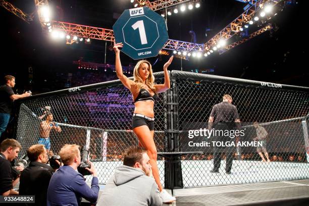 Octagon Girl holds up the round number board during a UFC fight at the O2 Arena in London on March 17, 2018. Accused of promoting an ultra-violent...