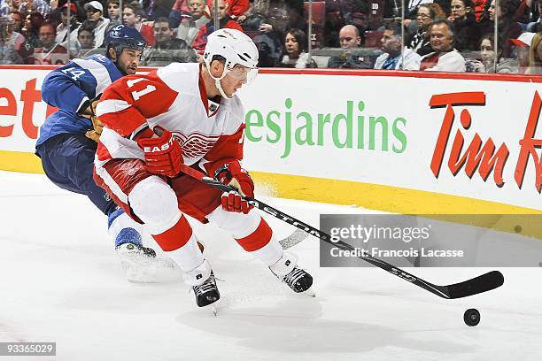 Daniel Cleary of the Detroit Red Wings skates with the puck chased by Roman Hamrlik of the Montreal Canadiens during the NHL game against Detroit Red...