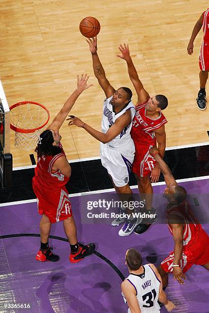 Kenny Thomas of the Sacramento Kings lays up a shot against Luis Scola and Shane Battier of the Houston Rockets during the game on November 13, 2009...