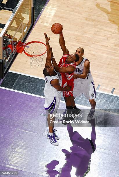 Carl Landry of the Houston Rockets puts up a shot against Kenny Thomas and Ime Udoka of the Sacramento Kings during the game on November 13, 2009 at...