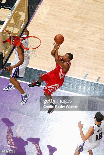 Kyle Lowry of the Houston Rockets puts up a shot between Kenny Thomas and Omri Casspi of the Sacramento Kings during the game on November 13, 2009 at...