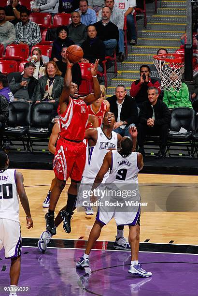 Carl Landry of the Houston Rockets puts up a shot against Jason Thompson and Kenny Thomas of the Sacramento Kings during the game on November 13,...