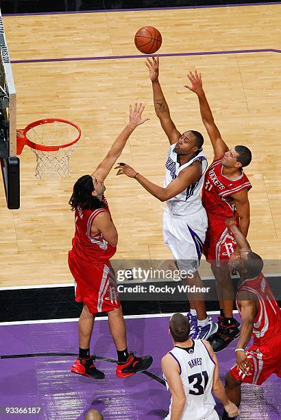 Kenny Thomas of the Sacramento Kings lays up a shot against Luis Scola and Shane Battier of the Houston Rockets during the game on November 13, 2009...