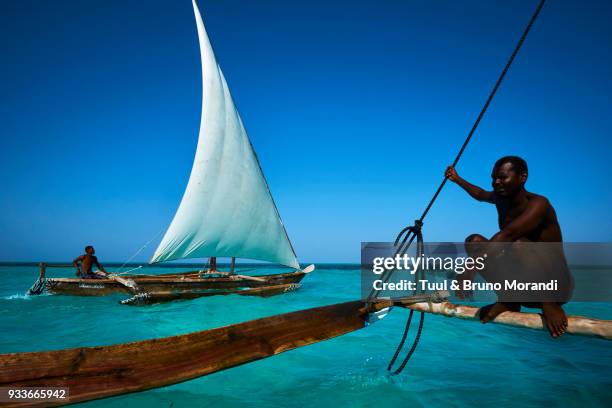 tanzania, zanzibar, fisher on local boat at jambiani - dhow stock pictures, royalty-free photos & images