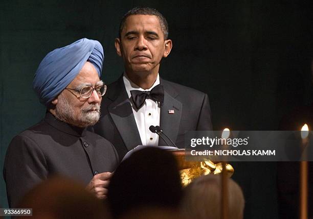 President Barack Obama listens to his Indian counterpart Manmohan Singh addressing the first official State Dinner of Obama's administration on the...