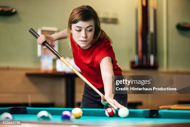 young woman concentrating while playing pool - pool cue stock pictures, royalty-free photos & images