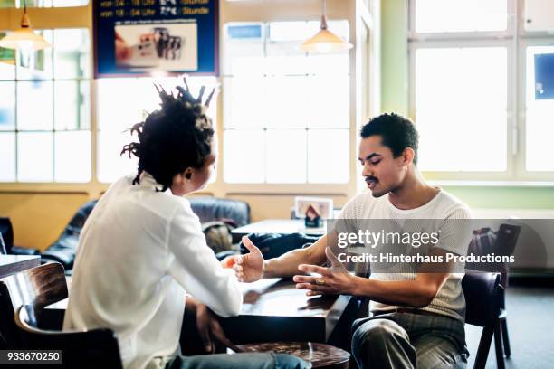 couple of friends sitting down chatting together at cafe - couple serious bildbanksfoton och bilder