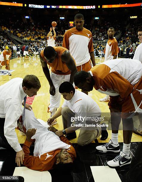 Coaches and medical staff attend to Jordan Hamilton of the Texas Longhorns who was injured in warm-ups prior to the start of the CBE Classic...