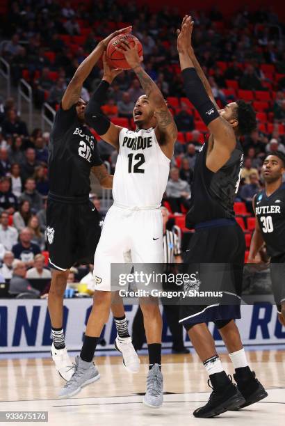 Vincent Edwards of the Purdue Boilermakers drives to the basket against Henry Baddley and Tyler Wideman of the Butler Bulldogs during the first half...