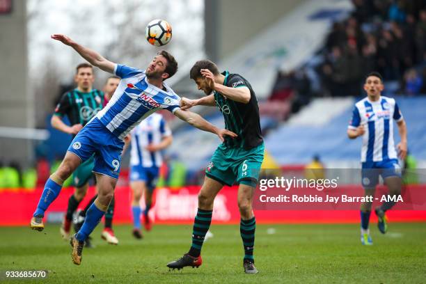 Will Grigg of Wigan Athletic and Wesley Hoedt of Southampton during The Emirates FA Cup Quarter Final match at DW Stadium on March 18, 2018 in Wigan,...