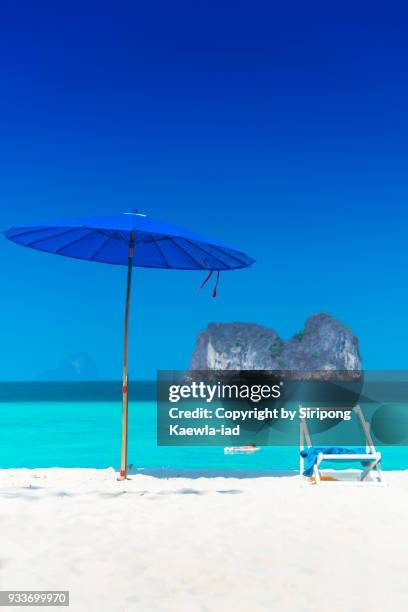 beach umbrella and chair with beautiful andaman sea in background. - copyright by siripong kaewla iad fotografías e imágenes de stock