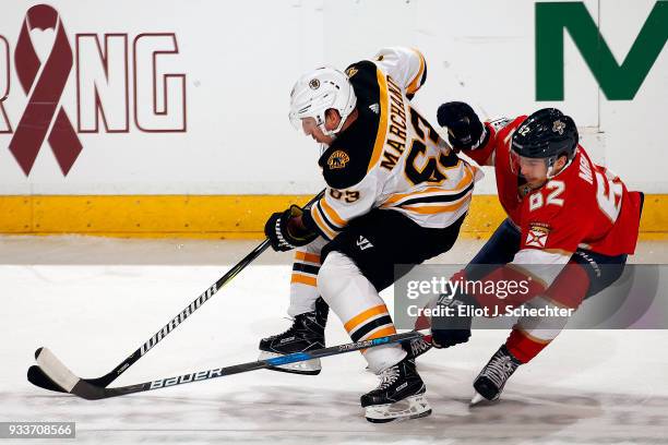 Brad Marchand of the Boston Bruins skates with the puck against Denis Malgin of the Florida Panthers at the BB&T Center on March 15, 2018 in Sunrise,...