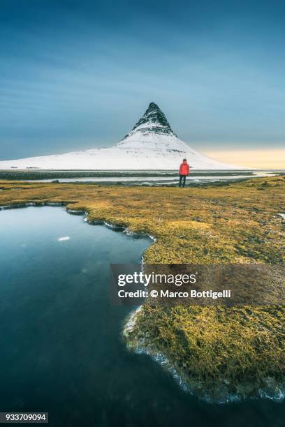 tourist admiring the view at kirkjufell mountain, iceland - snaefellsnes stock pictures, royalty-free photos & images