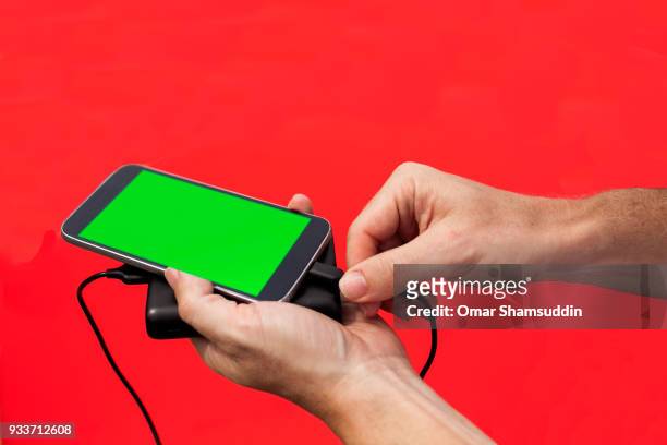 plugging in power bank charger for smartphone - omar shamsuddin stock-fotos und bilder