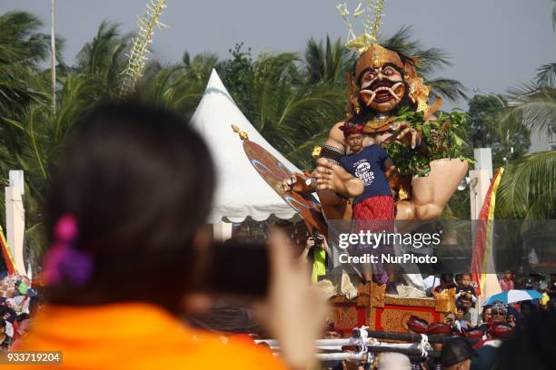 Visitor taking a photograph of giant effigy during an Effigy festival, known as Ogoh-ogoh, at Ancol beach, North Jakarta, on Sunday, March 18, 2018....