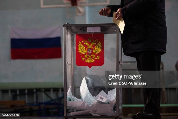 Man casts ballot paper during the 2018 Russian presidential election at a polling station in St.Petersburg. The Presidential election of Russia is...