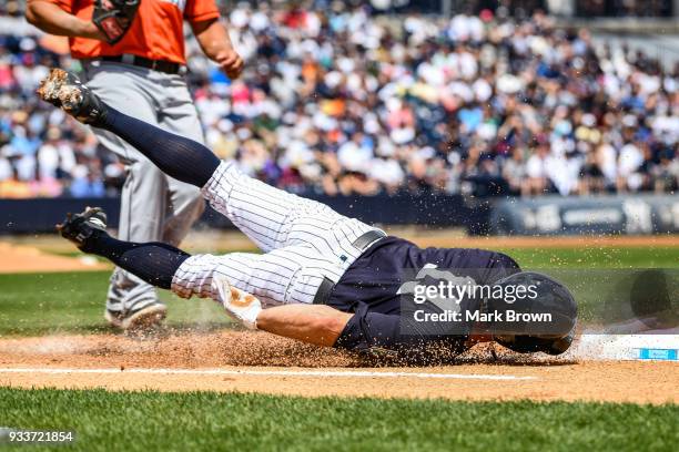 Brett Gardner of the New York Yankees slides into first base in the first inning during the spring training game between the New York Yankees and the...