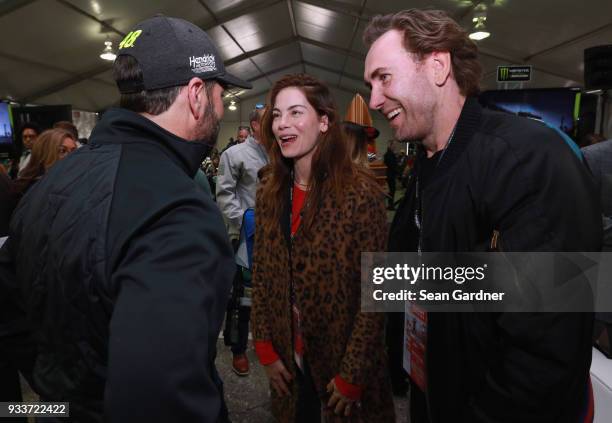 Jimmie Johnson, driver of the Lowe's for Pros Chevrolet, meets actress Michelle Monaghan and husband Petre White during the driver's meeting prior to...