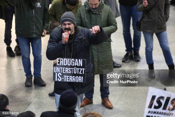 An activist with a sign saying 'Erdogan supports ISIS-Terrorism' speaks at the microphone. About 30-40 people protested spontaneously at the Munich...