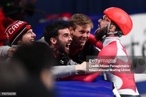 Charles Hamelin of Canada celebrates with brother Francois Hamelin and Pascal Dion in the men's 3000 meter SuperFinal during the World Short Track...