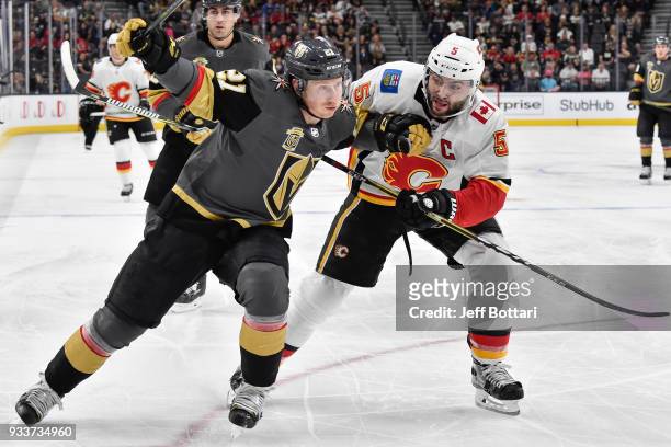 Cody Eakin of the Vegas Golden Knights and Mark Giordano of the Calgary Flames skate to the puck during the game at T-Mobile Arena on March 18, 2018...