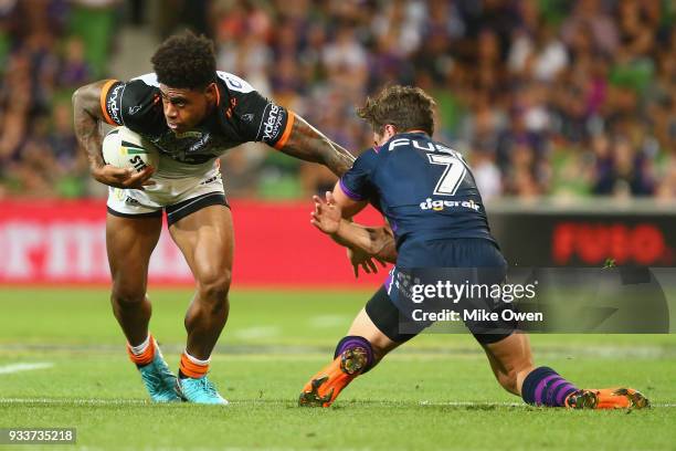 Kevin Naiqama of the Tigers breaks a takle from Brodie Croft of the Storm during the round two NRL match between the Melbourne Storm and the Wests...