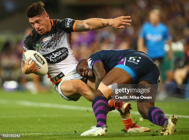 Malakai Watene-Zelezniak of the Tigers is tackled by Suliasi Vunivalu of the Storm during the round two NRL match between the Melbourne Storm and the...