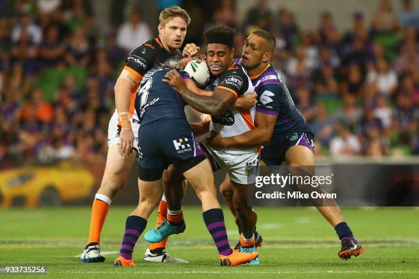 Kevin Naiqama of the Tigers is tackled during the round two NRL match between the Melbourne Storm and the Wests Tigers at AAMI Park on March 17, 2018...