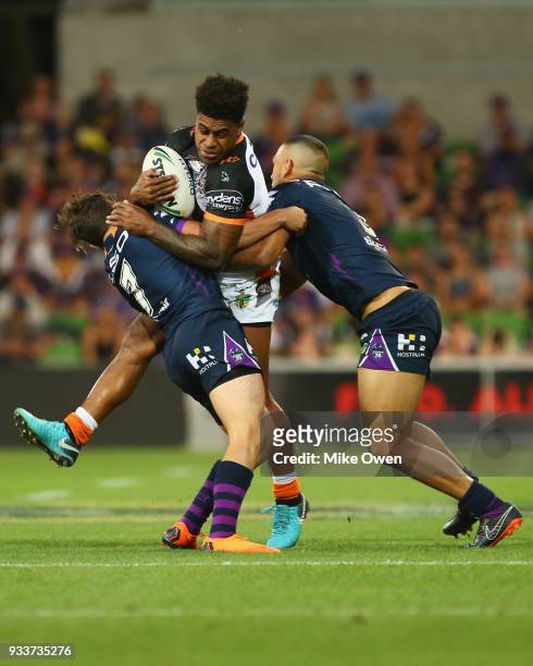 Kevin Naiqama of the Tigers is tackled during the round two NRL match between the Melbourne Storm and the Wests Tigers at AAMI Park on March 17, 2018...