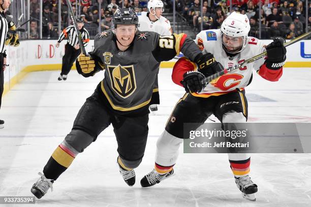 Cody Eakin of the Vegas Golden Knights and Mark Giordano of the Calgary Flames skate to the puck during the game at T-Mobile Arena on March 18, 2018...
