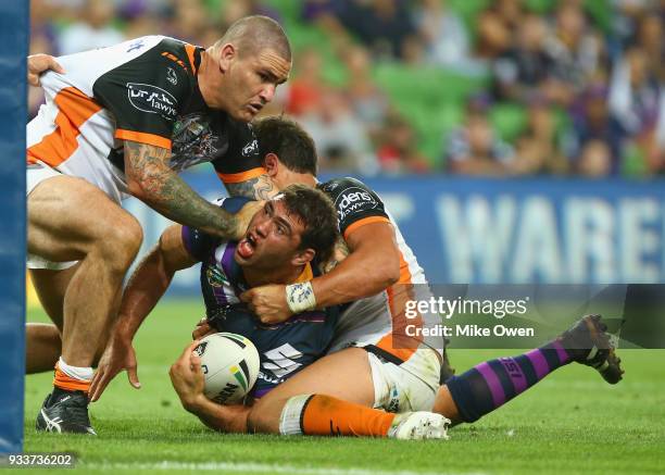 Dean Finucane of the Storm is tackled during the round two NRL match between the Melbourne Storm and the Wests Tigers at AAMI Park on March 17, 2018...