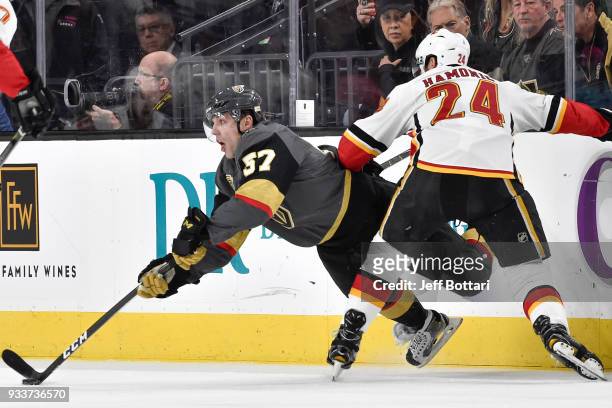 David Perron of the Vegas Golden Knights handles the puck with Travis Hamonic of the Calgary Flames defending during the game at T-Mobile Arena on...