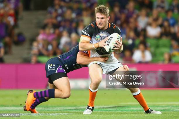 Chris Lawrence of the Tigers is tackled by Brodie Croft of the Storm during the round two NRL match between the Melbourne Storm and the Wests Tigers...