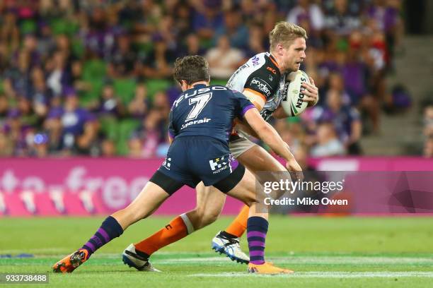 Chris Lawrence of the Tigers is tackled by Brodie Croft of the Storm during the round two NRL match between the Melbourne Storm and the Wests Tigers...