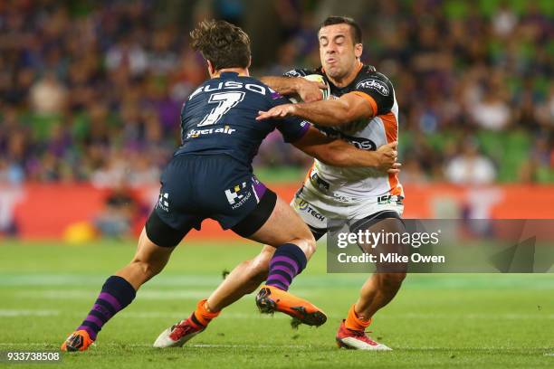 Luke Brooks of the Tigers is tackled by Brodie Croft of the Storm during the round two NRL match between the Melbourne Storm and the Wests Tigers at...