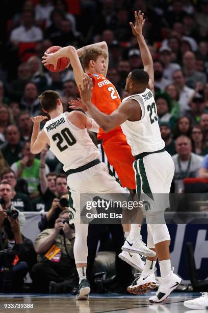 Marek Dolezaj of the Syracuse Orange handles the ball against Matt McQuaid and Xavier Tillman of the Michigan State Spartans during the second half...