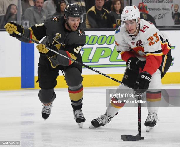 Sean Monahan of the Calgary Flames skates with the puck against Brayden McNabb of the Vegas Golden Knights in the first period of their game at...