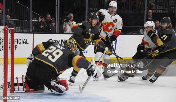 Marc-Andre Fleury of the Vegas Golden Knights blocks a shot by Micheal Ferland of the Calgary Flames as Brayden McNabb and William Karlsson of the...