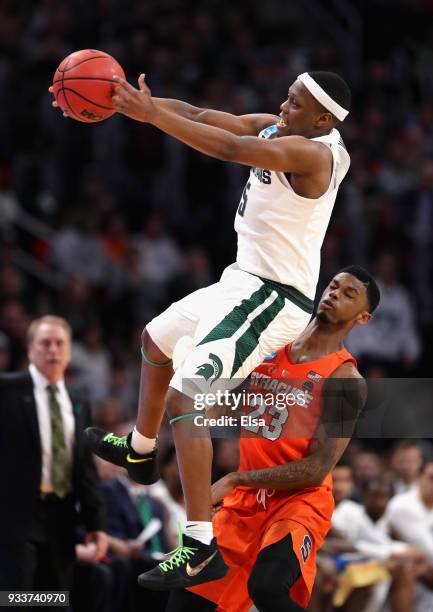 Cassius Winston of the Michigan State Spartans falls as he attempts to catch an inbounds pass against Frank Howard of the Syracuse Orange during the...