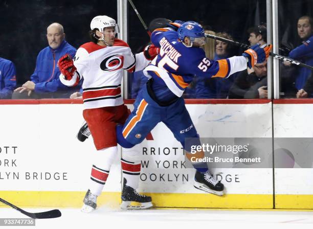 Johnny Boychuk of the New York Islanders hits Justin Williams of the Carolina Hurricanes into the boards during the first period at the Barclays...