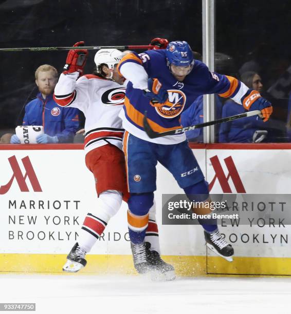 Johnny Boychuk of the New York Islanders hits Justin Williams of the Carolina Hurricanes into the boards during the first period at the Barclays...