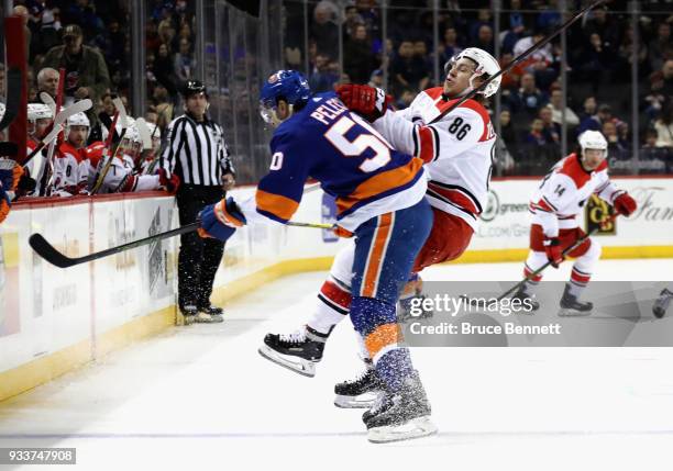 Adam Pelech of the New York Islanders checks Teuvo Teravainen of the Carolina Hurricanes during the first period at the Barclays Center on March 18,...