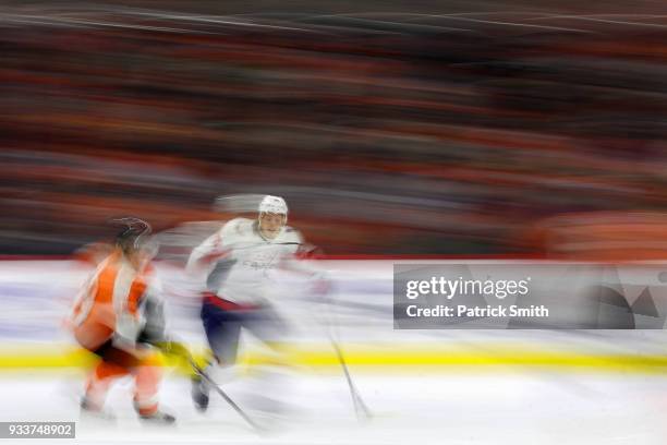 Jordan Weal of the Philadelphia Flyers skates with the puck as he is defended by John Carlson of the Washington Capitals during the first period at...