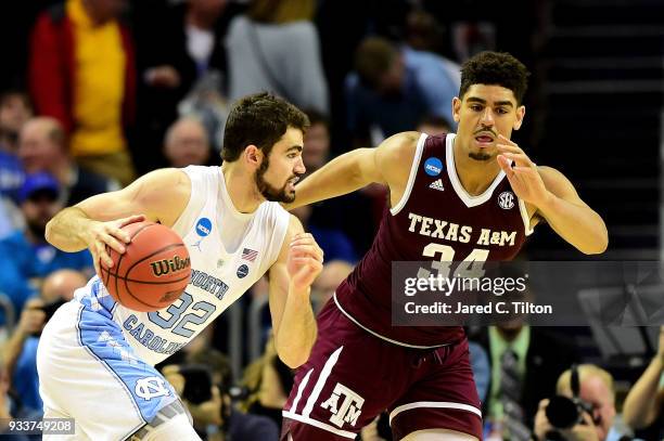 Luke Maye of the North Carolina Tar Heels drives to the basket against Tyler Davis of the Texas A&M Aggies during the second round of the 2018 NCAA...