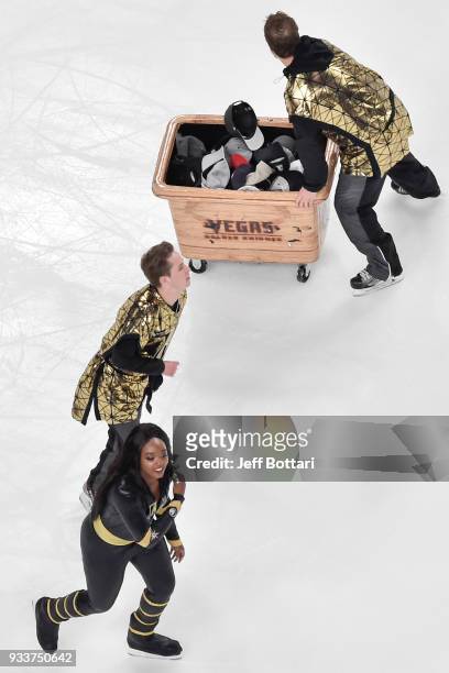 Members of the Knights Crew clean hats off the ice after William Karlsson of the Vegas Golden Knights scored his third goal of the second period...
