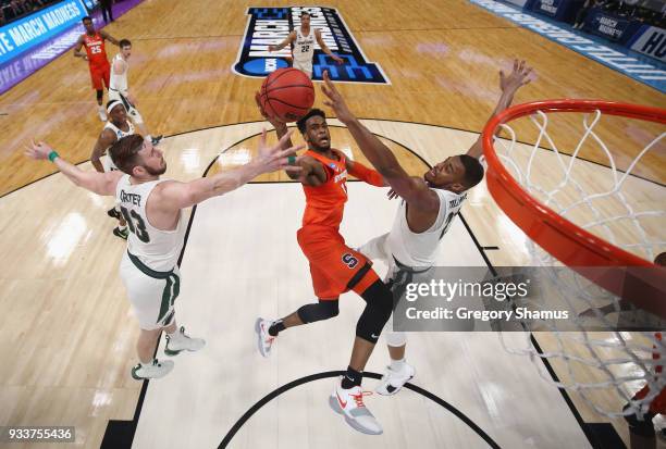 Oshae Brissett of the Syracuse Orange drives to the basket against Ben Carter and Xavier Tillman of the Michigan State Spartans in the second round...
