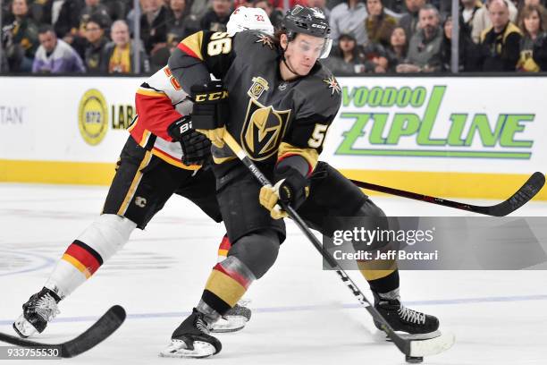 Erik Haula of the Vegas Golden Knights skates with the puck while Sean Monahan of the Calgary Flames defends during the game at T-Mobile Arena on...