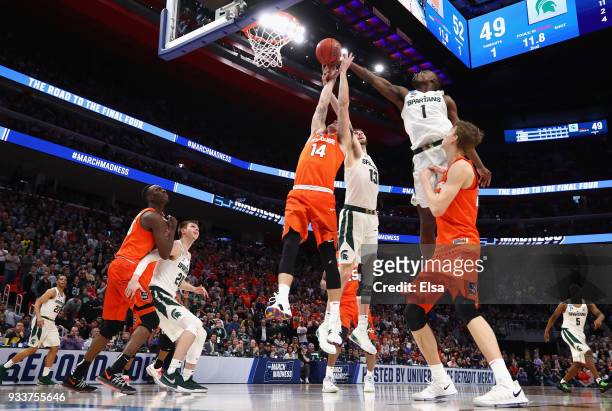 Braedon Bayer of the Syracuse Orange battles for the ball with Ben Carter and Joshua Langford of the Michigan State Spartans in the second round of...