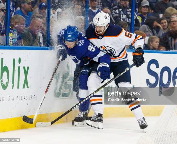 Mikhail Sergachev of the Tampa Bay Lightning battles against Anton Slepyshev of the Edmonton Oilers during the second period at Amalie Arena on March...