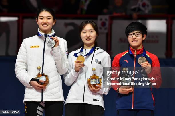 Suk Hee Shim of Korea, Min Jeong Choi of Korea and Jinyu Li of China hold up their medals after completing the women's 3000 meter SuperFinal during...